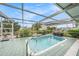 Outdoor screened-in pool area with comfortable lounging spaces, a canal view and lush landscape at 15525 Old Dixie Hwy, Hudson, FL 34667