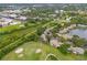 Aerial view of townhouse community with golf course views, green spaces, and a serene pond at 1724 Adams S Cir, Largo, FL 33771