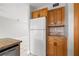 Kitchen area with wood cabinets, stone backsplash, granite countertops, and modern stainless refrigerator at 1724 Adams S Cir, Largo, FL 33771