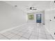 Open-concept living room with a ceiling fan, tile flooring, and an inviting blue entry door at 1724 Adams S Cir, Largo, FL 33771