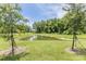 Spacious green backyard featuring a tranquil pond with surrounding trees at 17482 Nectar Flume Dr, Land O Lakes, FL 34638