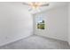 Bedroom with a ceiling fan, carpet and a bright window with a view of trees at 17482 Nectar Flume Dr, Land O Lakes, FL 34638
