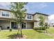 Back of townhome features a covered patio with sliding glass doors and lush lawn at 17482 Nectar Flume Dr, Land O Lakes, FL 34638