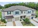 Charming townhome exterior featuring a two-car garage, neutral color palette, and manicured landscaping at 17482 Nectar Flume Dr, Land O Lakes, FL 34638