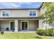 Back of townhome features a covered patio with sliding glass doors and well-maintained lawn at 17482 Nectar Flume Dr, Land O Lakes, FL 34638