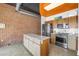 Industrial-style kitchen with stainless steel appliances, brick accent wall, and light wood cabinetry at 175 2Nd St S # P-2, St Petersburg, FL 33701