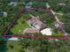 Aerial view of a sprawling estate with lush landscaping, mature trees, and ample space at 1835 Alicia Way, Clearwater, FL 33764