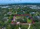 Aerial view showcasing a property with a tennis court and green trees, bordered for clarity at 1835 Alicia Way, Clearwater, FL 33764