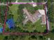 Aerial view showcases a sprawling estate with a tennis court and lush landscaping at 1835 Alicia Way, Clearwater, FL 33764