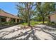 Beautiful backyard featuring a large tree, lush lawn, and a glimpse of the tennis court at 1835 Alicia Way, Clearwater, FL 33764