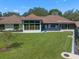 Expansive backyard with well-maintained lawn, modern windows, and architectural details on a sunny day at 1835 Alicia Way, Clearwater, FL 33764