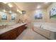 Elegant bathroom featuring a double vanity, Jacuzzi tub, and unique wall paintings at 1835 Alicia Way, Clearwater, FL 33764