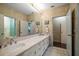 Modern bathroom with a large mirror, white vanity, and dual entrances at 1835 Alicia Way, Clearwater, FL 33764