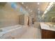 Spacious bathroom featuring a Jacuzzi tub, double vanity, and glass-enclosed shower at 1835 Alicia Way, Clearwater, FL 33764
