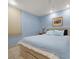 Cozy bedroom with a queen-size bed, soft blue walls, and a large window at 1835 Alicia Way, Clearwater, FL 33764
