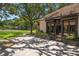 Exterior featuring dark trim windows, landscaped flower beds, and glimpses of tennis court at 1835 Alicia Way, Clearwater, FL 33764