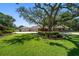 Home exterior with a well-manicured lawn and beautiful landscaping, enhanced by mature trees and flowering plants at 1835 Alicia Way, Clearwater, FL 33764