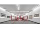 A large garage featuring multiple car lifts and ample space for automotive projects and displaying automotive art at 1835 Alicia Way, Clearwater, FL 33764