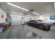 Garage with a car and storage, featuring multiple garage doors and a mounted TV at 1835 Alicia Way, Clearwater, FL 33764