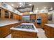 Gourmet kitchen featuring a central island with cooktop and stainless steel appliances at 1835 Alicia Way, Clearwater, FL 33764