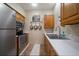 Kitchen featuring stainless steel appliances, wooden cabinetry, and tile backsplash at 1835 Alicia Way, Clearwater, FL 33764