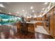 Open-concept kitchen with an island bar next to a large indoor pool and lots of cabinet space at 1835 Alicia Way, Clearwater, FL 33764