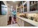 Custom liquor cabinet with glass doors and countertops, adjacent to a hallway and indoor pool at 1835 Alicia Way, Clearwater, FL 33764