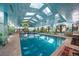 Indoor pool area with a mural, skylights, and comfortable seating, perfect for relaxation at 1835 Alicia Way, Clearwater, FL 33764