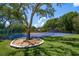 A tennis court surrounded by mature trees, providing a private and scenic space for recreation at 1835 Alicia Way, Clearwater, FL 33764