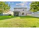 This backyard features a lush lawn, covered patio, and the exterior of the two-story home at 19656 Long Lake Ranch Blvd, Lutz, FL 33558