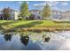 The backyard of a home, with a tranquil pond backdrop featuring lily pads and reflected trees under a bright sky at 19656 Long Lake Ranch Blvd, Lutz, FL 33558