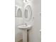 Clean half bathroom with pedestal sink, oval mirror and white walls at 19656 Long Lake Ranch Blvd, Lutz, FL 33558