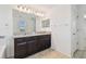 Bathroom with dual sinks, a large mirror, and dark wood cabinets at 19656 Long Lake Ranch Blvd, Lutz, FL 33558