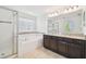 Bright bathroom featuring dual sinks, white cabinets, and a walk-in glass shower and separate tub at 19656 Long Lake Ranch Blvd, Lutz, FL 33558