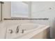 Modern bathtub featuring chrome fixtures and decorative tile accents at 19656 Long Lake Ranch Blvd, Lutz, FL 33558