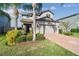 Attractive two-story home with a brick-paved driveway, two-car garage, and lush, tropical landscaping at 19656 Long Lake Ranch Blvd, Lutz, FL 33558