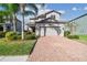Charming two-story home featuring a brick driveway, two-car garage, and well-manicured landscaping at 19656 Long Lake Ranch Blvd, Lutz, FL 33558