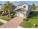 Stunning aerial front view of a two-story home featuring a brick driveway, manicured landscaping, and a two-car garage at 19656 Long Lake Ranch Blvd, Lutz, FL 33558