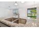 Modern kitchen features granite counters, stainless steel sink and a view of the backyard and lake at 19656 Long Lake Ranch Blvd, Lutz, FL 33558
