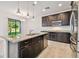 Kitchen island with granite counters and stainless steel appliances, open to the dining and living areas at 19656 Long Lake Ranch Blvd, Lutz, FL 33558
