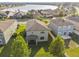 An aerial perspective shows a home's backyard with tidy green lawn and the surrounding residential area near a small lake at 19656 Long Lake Ranch Blvd, Lutz, FL 33558