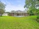Expansive backyard with screened-in pool and lush green lawn perfect for relaxation and entertainment at 2409 Heather Manor Ln, Lutz, FL 33549