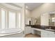 A bright bathroom features a soaking tub under the large windows at 2409 Heather Manor Ln, Lutz, FL 33549