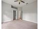 Spacious bedroom featuring neutral walls, ceiling fan, carpeted floor and an open closet space at 2409 Heather Manor Ln, Lutz, FL 33549