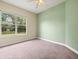 Bright bedroom with ceiling fan and a large window overlooking the lush landscaping at 2409 Heather Manor Ln, Lutz, FL 33549