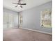 Spacious bedroom featuring a ceiling fan, carpet flooring, and bright windows at 2409 Heather Manor Ln, Lutz, FL 33549