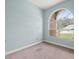 Cozy bedroom with large arched window and neutral carpet flooring at 2409 Heather Manor Ln, Lutz, FL 33549