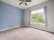Spacious bedroom with a large window and soft purple curtains, offering ample natural light at 2409 Heather Manor Ln, Lutz, FL 33549