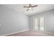 Bedroom boasts natural light, carpet flooring, ceiling fan, and french doors at 2409 Heather Manor Ln, Lutz, FL 33549