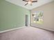 Comfortable bedroom with a ceiling fan and a view of the well-maintained lawn at 2409 Heather Manor Ln, Lutz, FL 33549